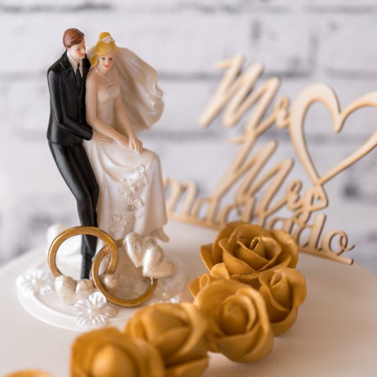 Hochzeitstorte aus Buttercreme einstöckig mit Brautpaar, Topper & Rosen in gold